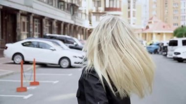 Kamera genç ve çekici bir kızı izliyor. Kadınlar yürür