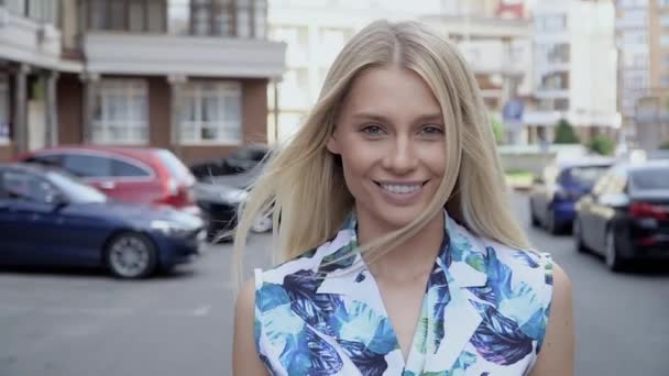 Blond in een zomerpak poserend op de parkeerplaats. Camera bedrading. Vrouwenwandeling — Stockvideo