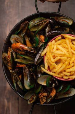 Kızarmış patates ile haşlanmış midye. Paylaşacak yemek. Deniz ürünleri.