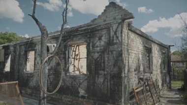 A war correspondent photographs a destroyed and burnt-out building from the outside and from the inside