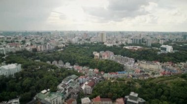 Aerial panorama view of smart colorful buildings in the green part of city 4K