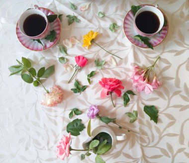 Kahve, çaydanlık, renkli çiçekler masanın üstünde..