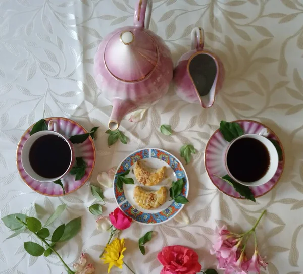 Two Cups Coffe Teapot Pastries Colourful Flowers 免版税图库照片