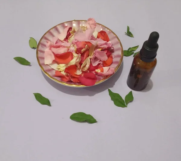 Aroma Therapy. Rose petals and small medicine bottle. Natural tonic. Organic tonic. Flower oil.