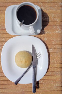 A cup of hot drink. Cookies on a plate next to it.