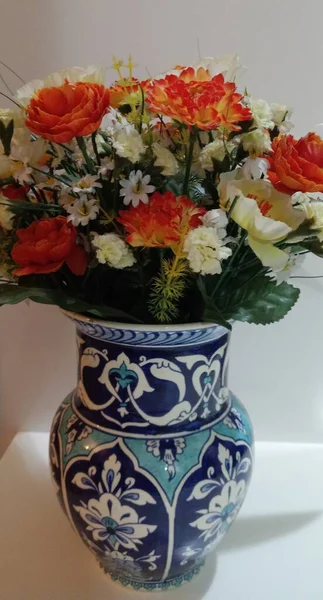 Artificial flowers in a blue vase. Blue vase made in Kutahya. Turkey. Handmade. Traditional vase. Closeup.