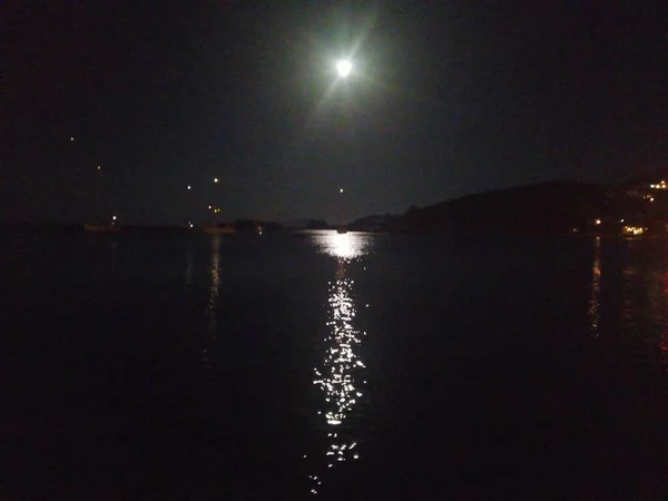 The reflection of the moonlight on the sea at night. Sea sparkle. Night shot.