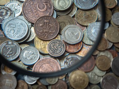 close up of old vintage coins  through a magnifying glass, financial background