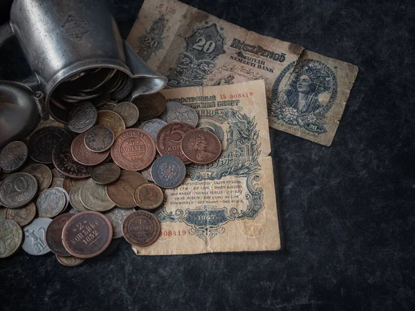 close up of old vintage coins with  and old  banknotes on black background,  financial concept