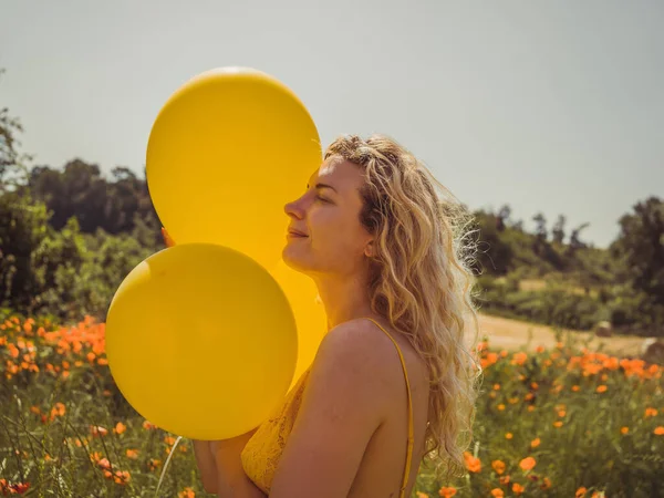 relax girl holding yellow balloons wearing yellow dress