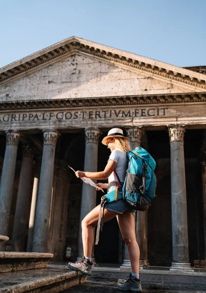 vertical shot of Young woman holds her map of Rome to discover the city and get to know it better, digital nomad