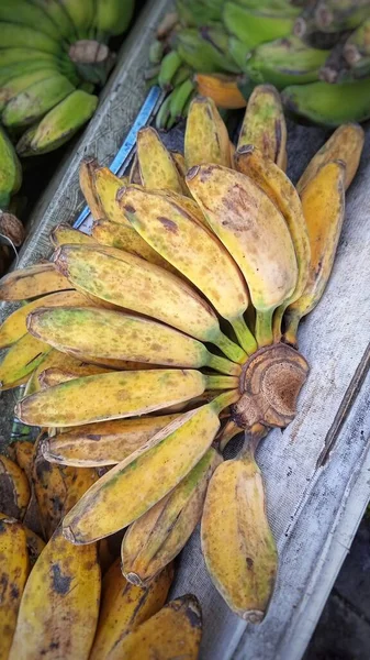 Saba bananas (Pisang Kepok) on a wooden couch. This banana belongs to the banana group because of its high starch content. This banana is usually processed into cake or snacks.