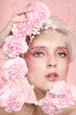 Yüzü sarı saçlı, doğal makyajlı, açık tenli bir kadın. Güzellik gözcüleri