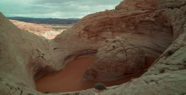 Tourists and hikers visit a unique sandstone geological feature known as the 'Cosmic Ashtray' located in Grand Staircase-Escalante National Monument. Time-lapse.