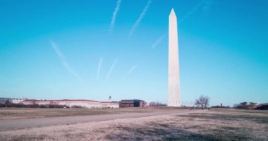 A panning time-lapse of tourists visiting the Washington Monument, located on the National Mall in Washington, DC on a winter afternoon. The wide-angle shot pans from left to right.