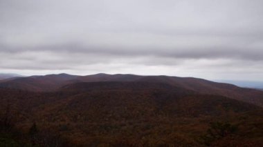 A time lapse of clouds rushing over Porter Ridge and the Appalachian Trail as seen from Spy Rock in the Blue Ridge Mountains in the George Washington National Forest in Nelson County Virginia. The forest is awash with fall colors. 