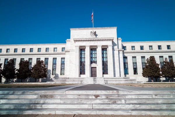 Güneşli bir kış gününde Washington, D.C. 'deki Marriner S. Eccles Federal Rezerv Kurulu binası. Constitution Avenue NW 'nin güney girişinden geniş açı. Parlak mavi gökyüzü bulutsuz.