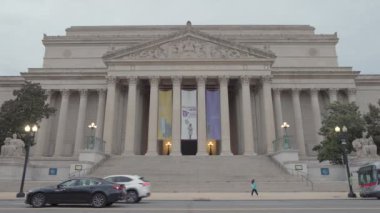Washington şehir merkezindeki Ulusal Arşiv Binası. Kış günü hava karardığında, Constitution Avenue NW 'den görülmüş. Araç ve turist trafiği geçiyor..