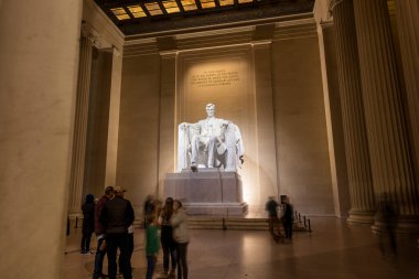Turistler bir kış gecesi Washington, D.C. 'deki Lincoln Anıtı' nı ziyaret ederler. Uzun bir pozlama, Başkan Abraham Lincoln 'ün etkileyici heykelinin altında oturan insanları bulanıklaştırdı..