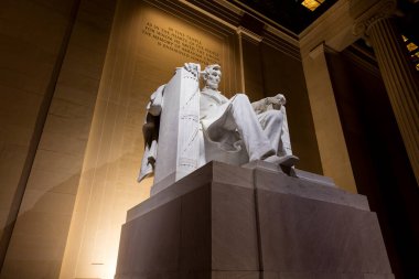 Abraham Lincoln heykeli, Daniel Chester French tarafından yontulmuş ve Piccirilli Kardeşler tarafından oyulmuş, gece Washington, D.C. 'deki Lincoln Anıtı' nda. Düşük açı geniş açı.