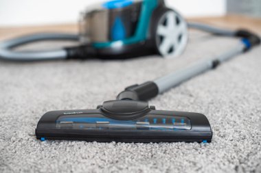 Gri bir halıdaki elektrik süpürgesinden fırçalar.