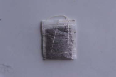 Beyaz arkaplanda beyaz kağıda sarılı çay poşetleri