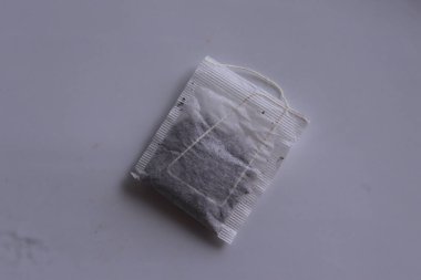 Beyaz arkaplanda beyaz kağıda sarılı çay poşetleri