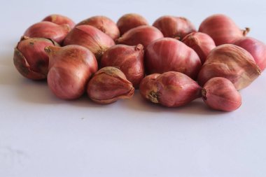 Beyaz arkaplanda izole edilmiş kırmızı soğanlar var.