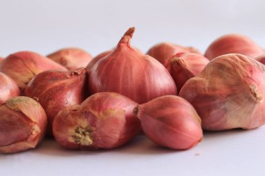 Beyaz arkaplanda izole edilmiş kırmızı soğanlar var.