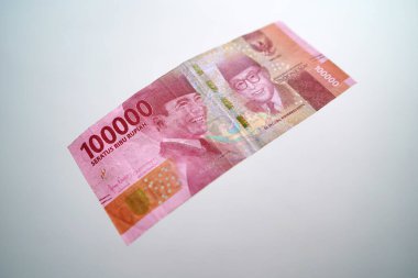 One hundred thousand rupiah banknote. Close-up of Soekarno and Hatta's faces on the front of the banknotes.