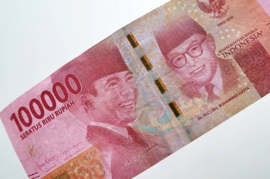 Close up of the 100 thousand rupiah banknote. Close up view of Soekarno and Hatta faces on the front of banknotes.