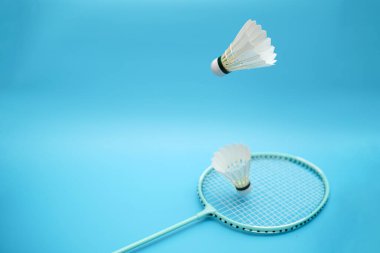 Two badminton shuttlecock and badminton racket on blue background