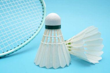 Badminton shuttlecock and badminton racket on blue background