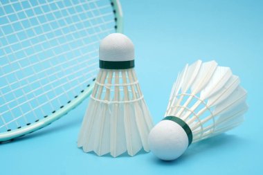 Badminton shuttlecock and badminton racket on blue background
