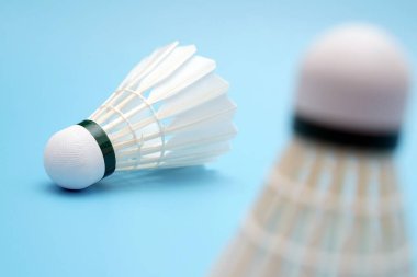 Badminton shuttlecock on foreground Badminton shuttlecock on blue background