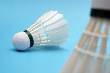 Badminton shuttlecock on foreground Badminton shuttlecock on blue background