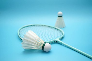 Badminton shuttlecock and badminton racket on blue background