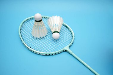 Badminton shuttlecock and badminton racket on blue background