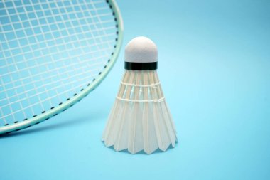 Badminton shuttlecock and badminton racket on blue background