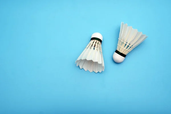 Two badminton shuttlecock on blue background