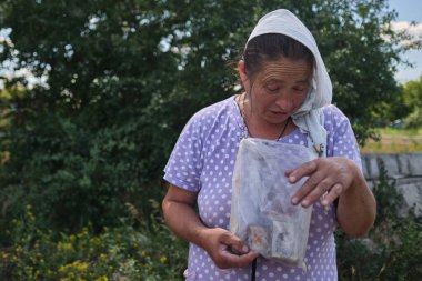 Tsirkuny, Harkivska Oblastı, 1 Temmuz 2022. Köylü bir kadın, Rus işgalinden kurtulmuş bir köyde barış için dua ediyor. İkonlarının kurşun geçirmez yelek gibi çalıştığını söylüyor.. 