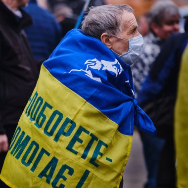 Kharkiv, Ukrayna. 22 Şubat 2022. Ukrayna bayrağı ve sloganı olan yaşlı bir adam 
