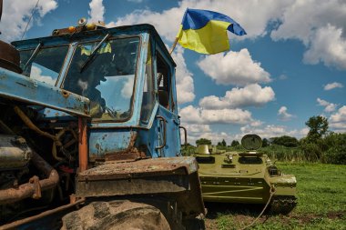 Mala Rogan, Kharkiv Oblast, Ukraine. July 29, 2022. Ukrainian farmer in his tractor towing a Russian trophy armored vehicle.