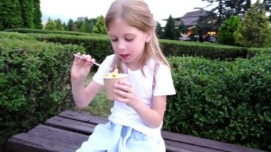 Dışarıda dondurma yiyen küçük bir kız. Yüksek kalite 4k görüntü