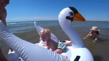 Küçük çocuk şişme kuğuya biniyor. Yüksek kalite 4k görüntü