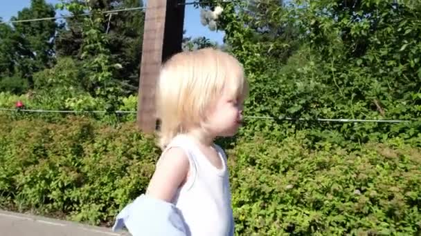 Mały Słodki Chłopiec Wchodzi Przez Bramę Parku Wysokiej Jakości Materiał — Wideo stockowe