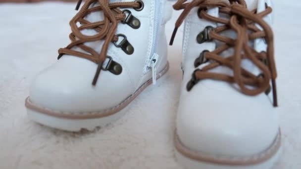 ベッドの上にレースのついた白い赤ん坊の靴 高品質4K映像 — ストック動画