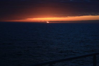 Gün batımı açık deniz bulutlu koyu kırmızı 