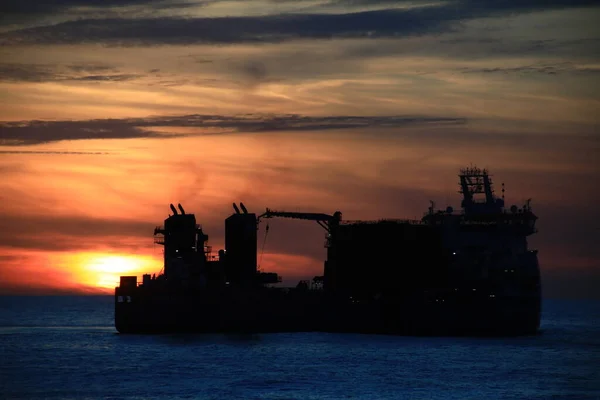 Bulutlu arkaplan ile gün batımında gemi
