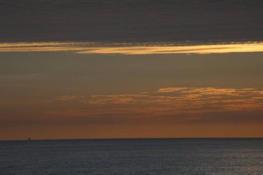 Kıyı açıklarında bulutlu gün batımı Kuzey denizi